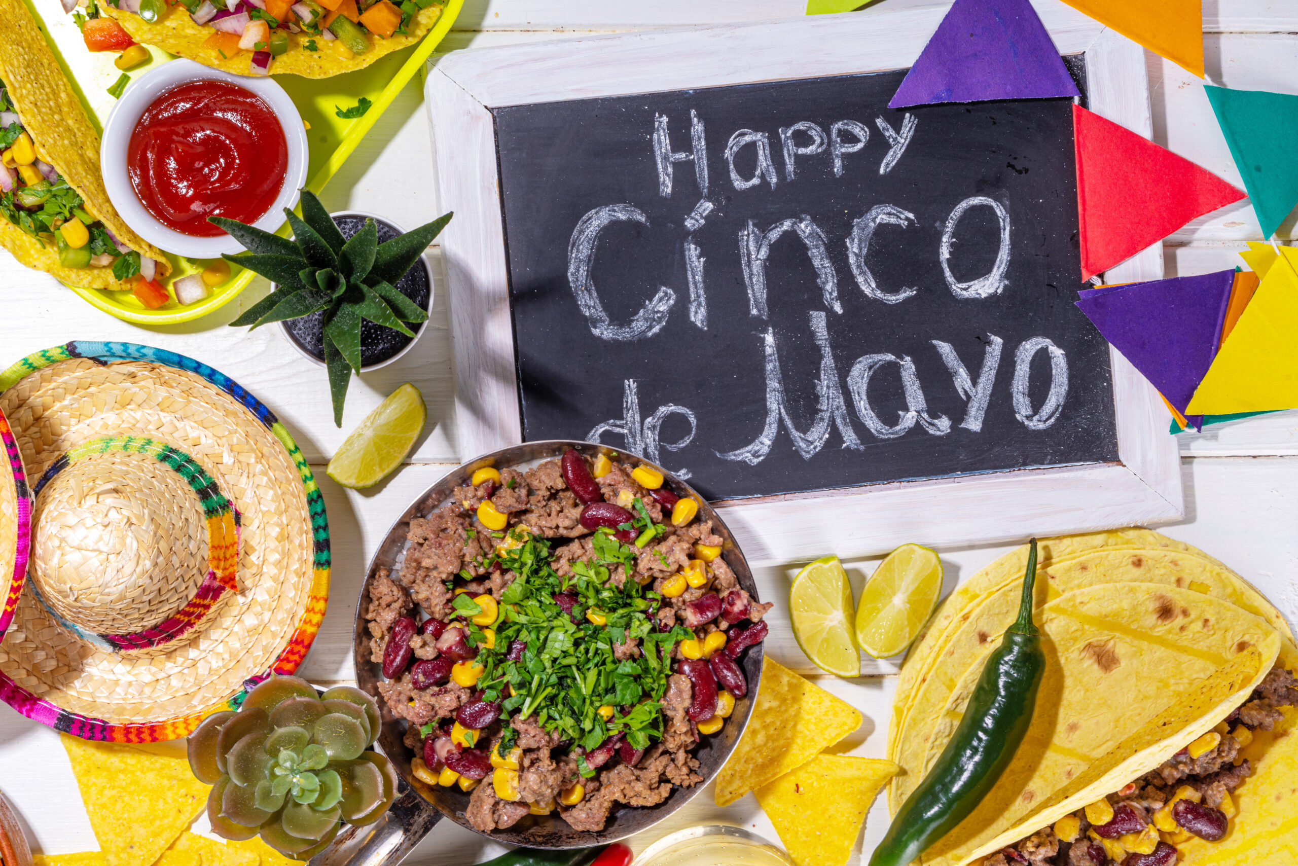 Cinco de mayo party food. Mexican holiday Cinco de mayo traditional dishes, snacks, tortilla corn chips, nachos, tacos, salsa, sauces. Friends and family feast background top view copy space